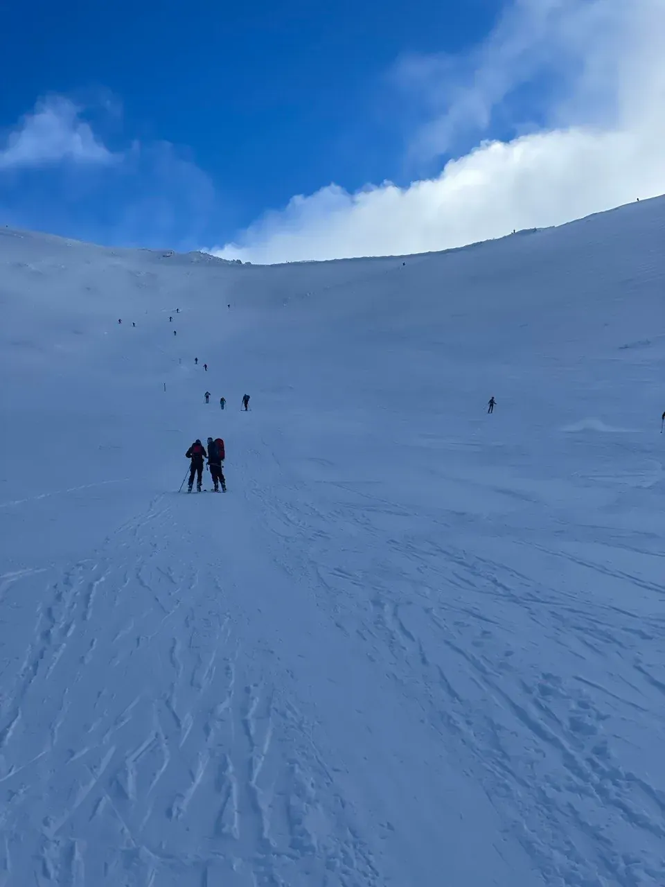 Skiers on the slope below Kasprowy Wierch on a sunny winter day